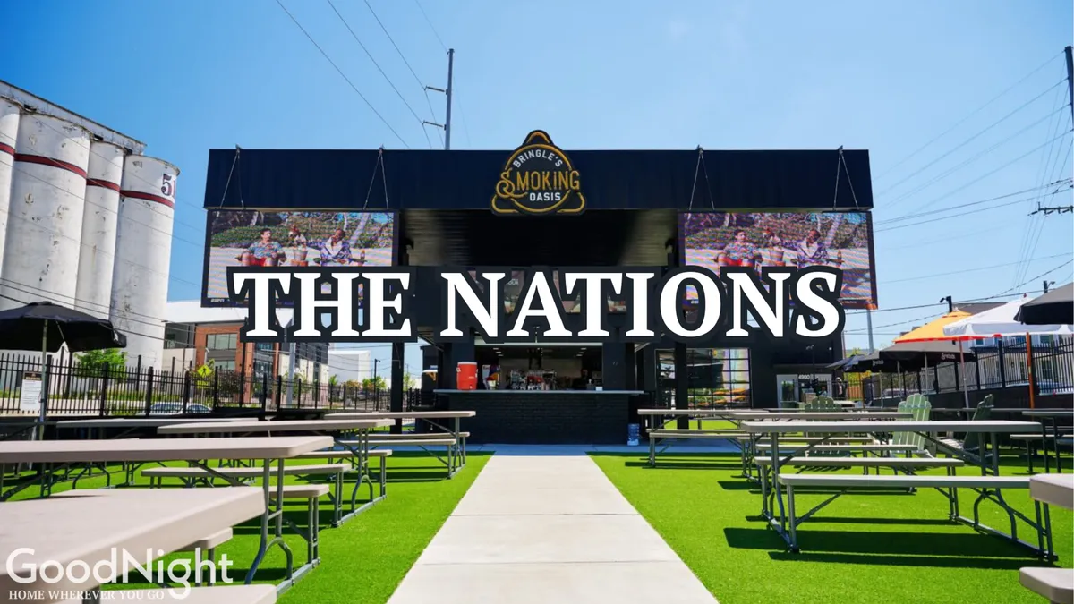 A lively exterior shot featuring 'THE NATIONS' sign, outdoor seating, and a food service area buzzing with activity. The festive mood is driven by digital screens, community engagement, and the casual vibe of the neighborhood.