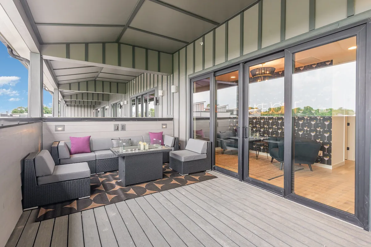 An inviting exterior patio setting with comfortable outdoor seating and a glass coffee table, ideal for relaxing, socializing, and group gatherings at the property itself. The stylish design and open-air feel emphasize communal enjoyment.